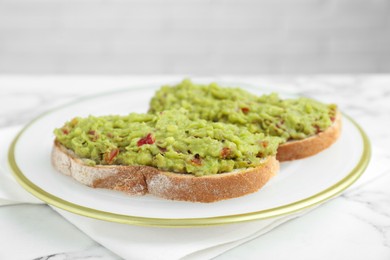 Photo of Delicious sandwiches with guacamole on white table, closeup