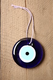 Photo of Evil eye amulet on wooden table, top view