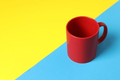 Photo of One red ceramic mug on color background. Space for text