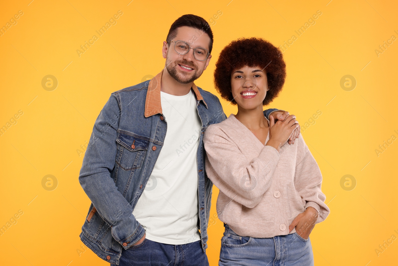 Photo of International dating. Portrait of happy couple on orange background