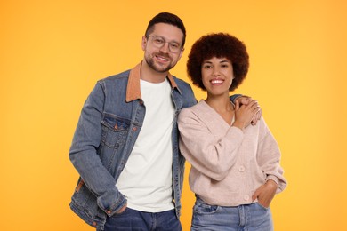 Photo of International dating. Portrait of happy couple on orange background