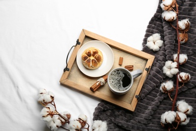 Photo of Flat lay composition with hot drink and warm plaid on white bedsheet