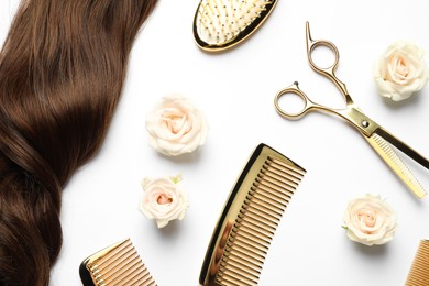 Flat lay composition with different hairdresser tools and flowers on white background