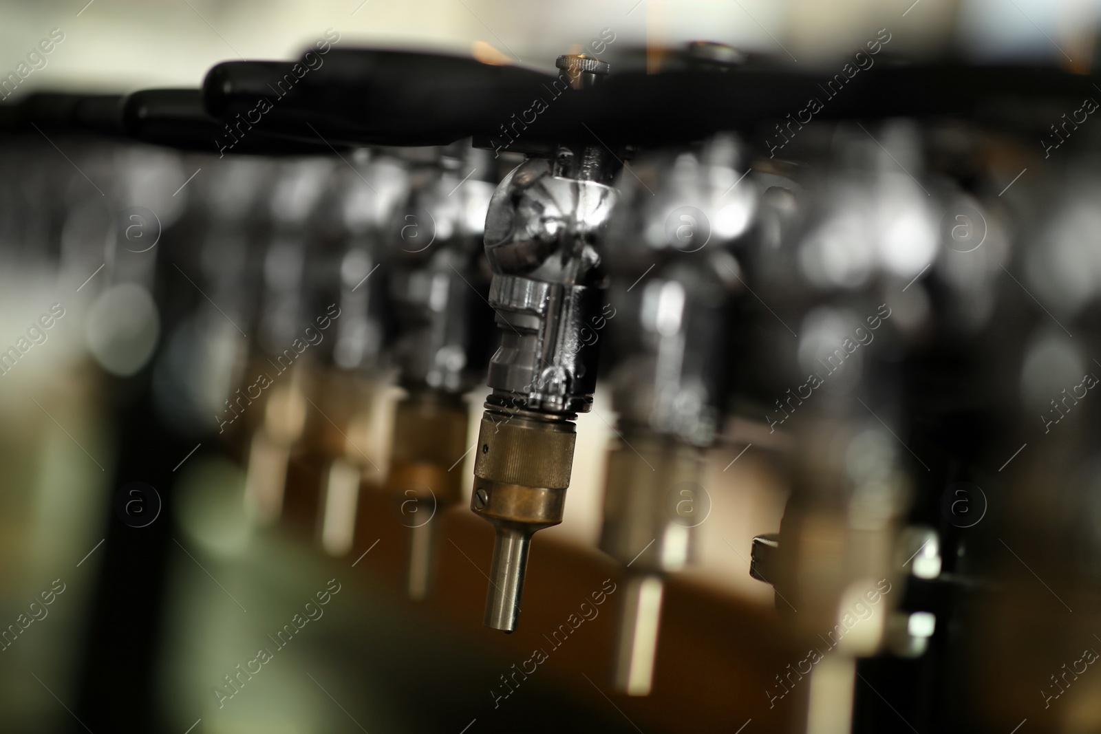 Photo of New modern beer taps in pub, closeup. Professional bar equipment