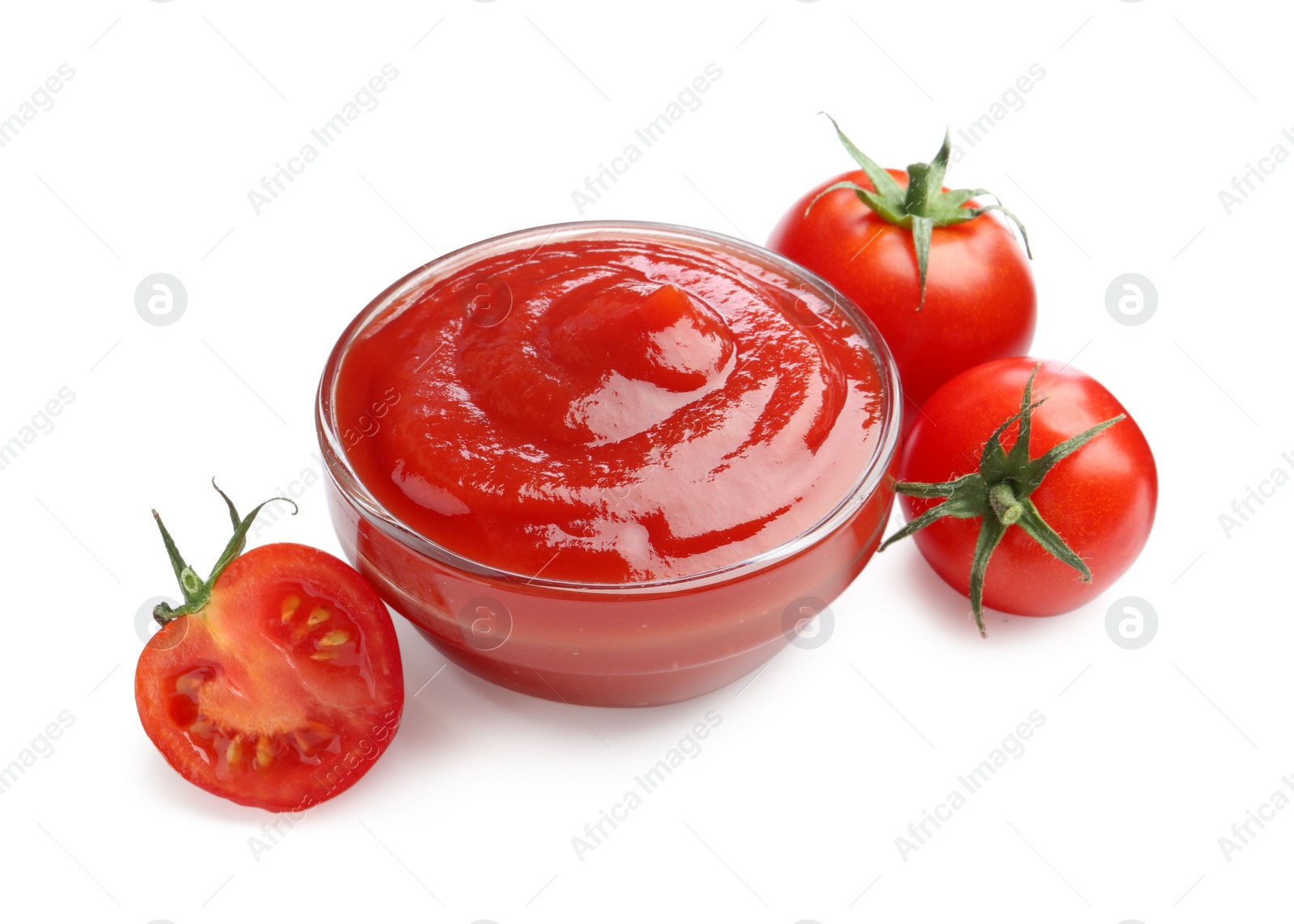 Photo of Tasty ketchup in glass bowl and fresh tomatoes isolated on white