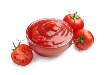 Photo of Tasty ketchup in glass bowl and fresh tomatoes isolated on white