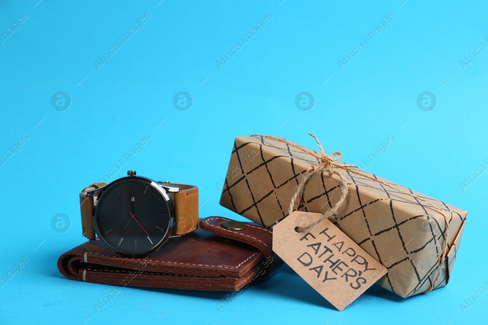 Photo of Gift box and male accessories on light blue background. Happy Father's Day