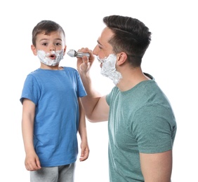 Photo of Dad applying shaving foam onto son's face against white background