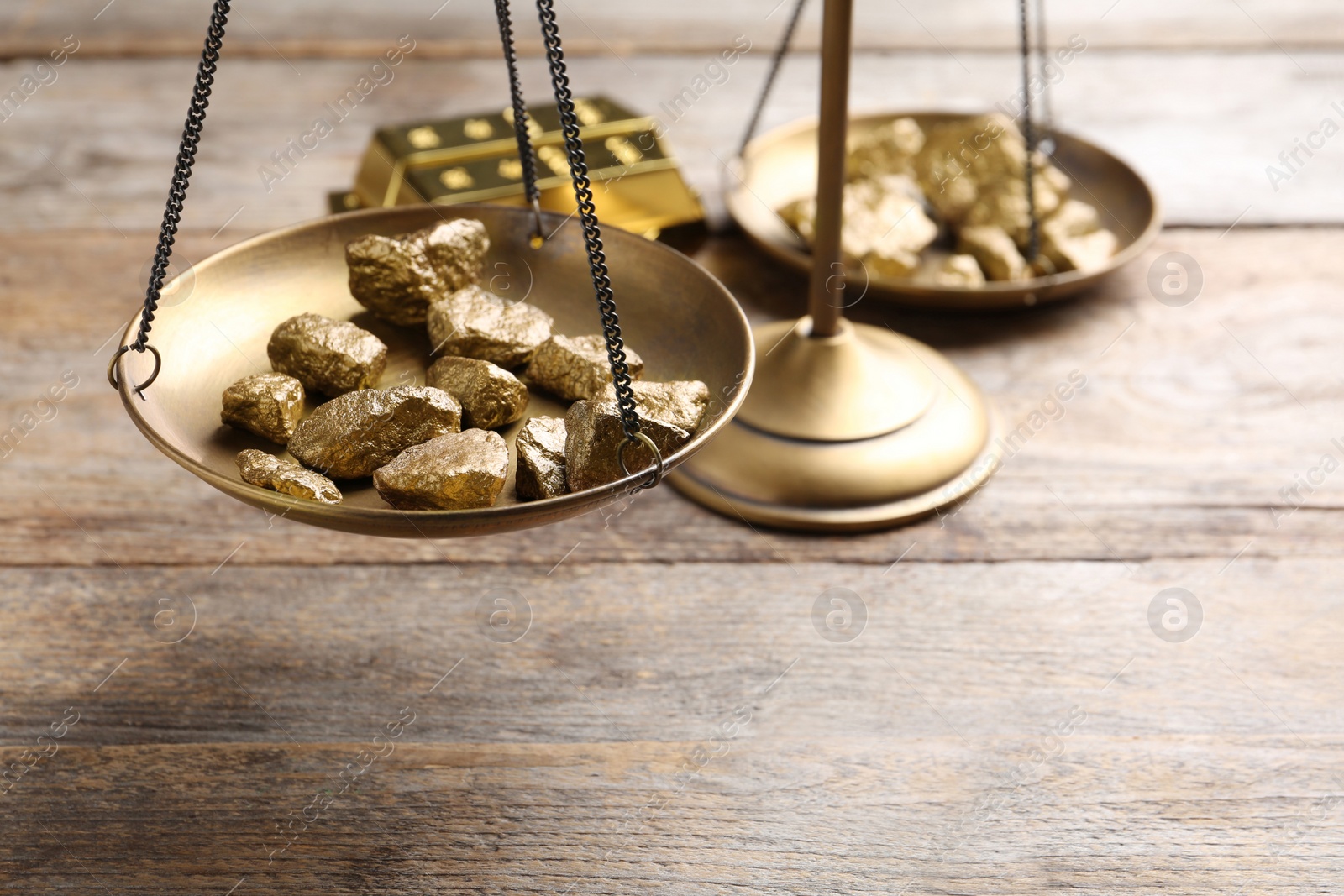 Photo of Scale pan with gold lumps on wooden table, closeup. Space for text