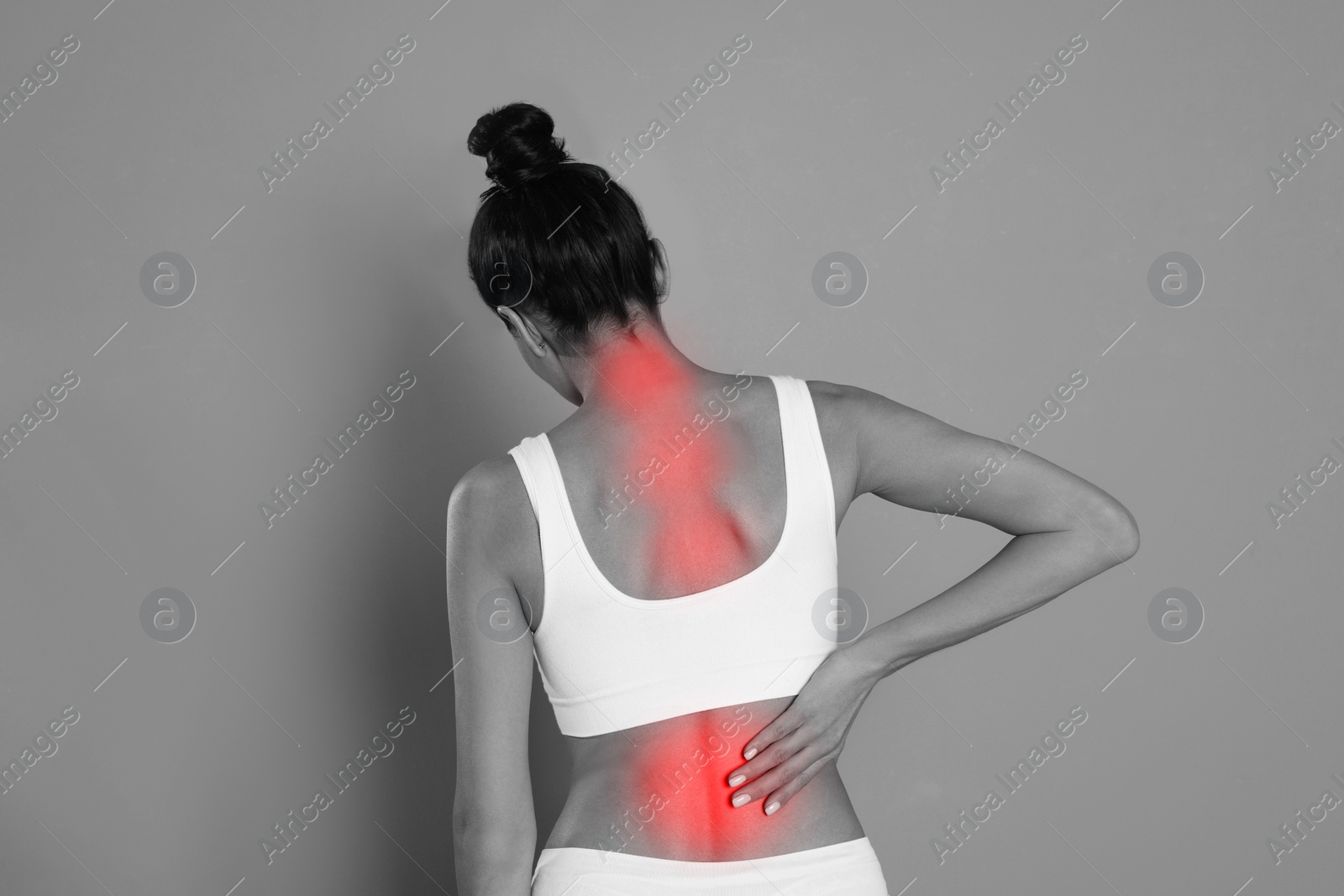 Image of Woman suffering from back pain on grey background