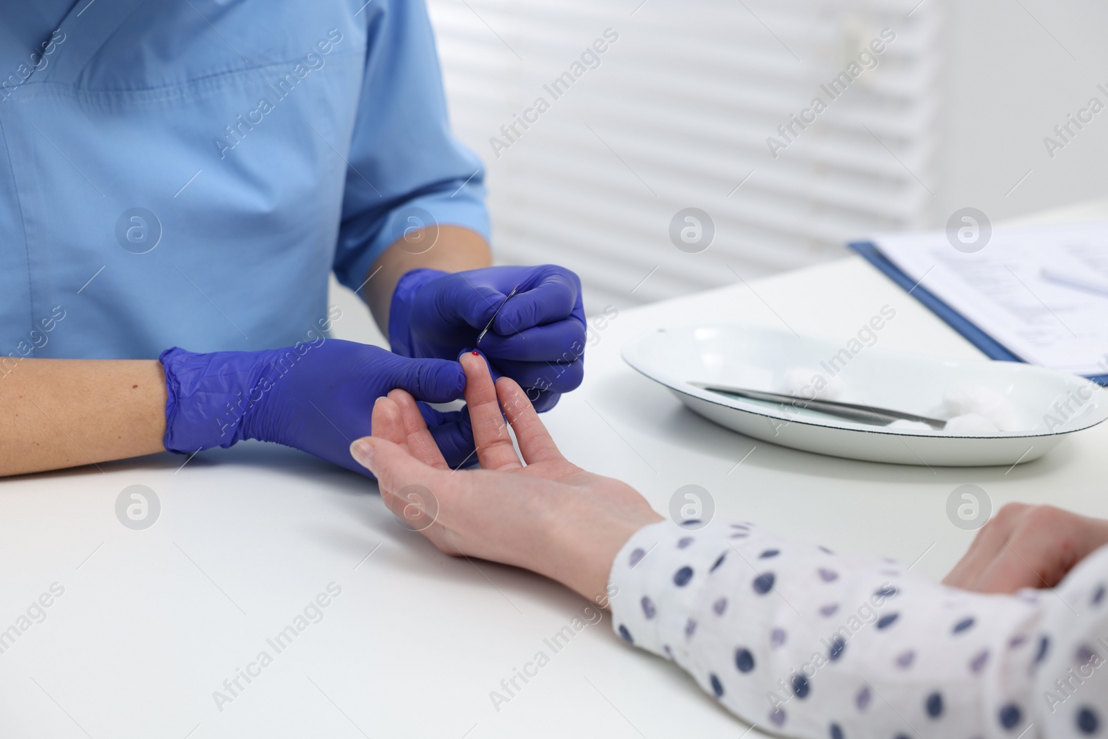 Photo of Laboratory testing. Doctor taking blood sample from patient at white table in hospital, closeup