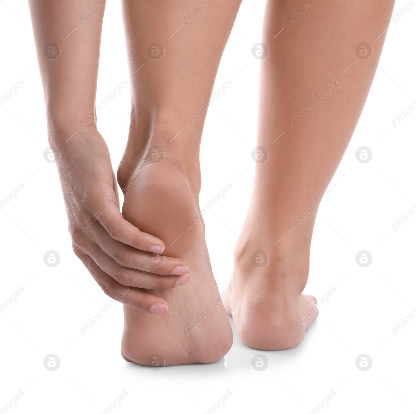 Photo of Young woman suffering from pain in foot on white background, closeup