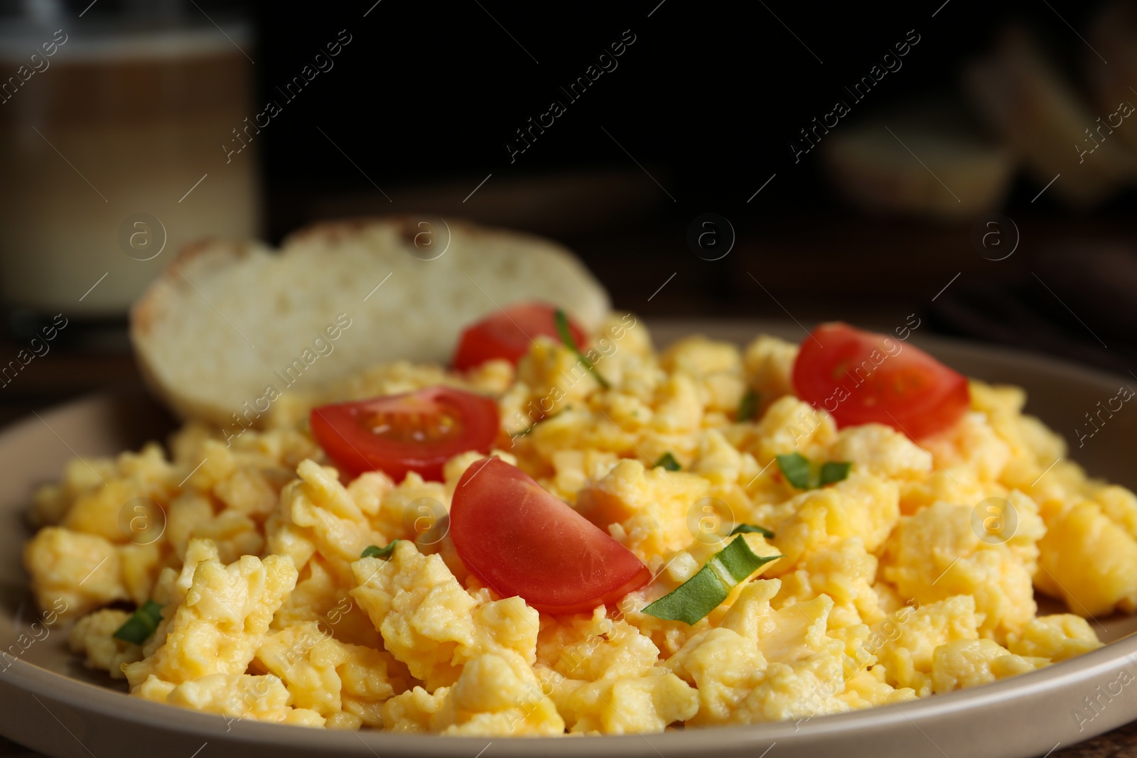 Photo of Tasty scrambled eggs with cherry tomato on plate, closeup