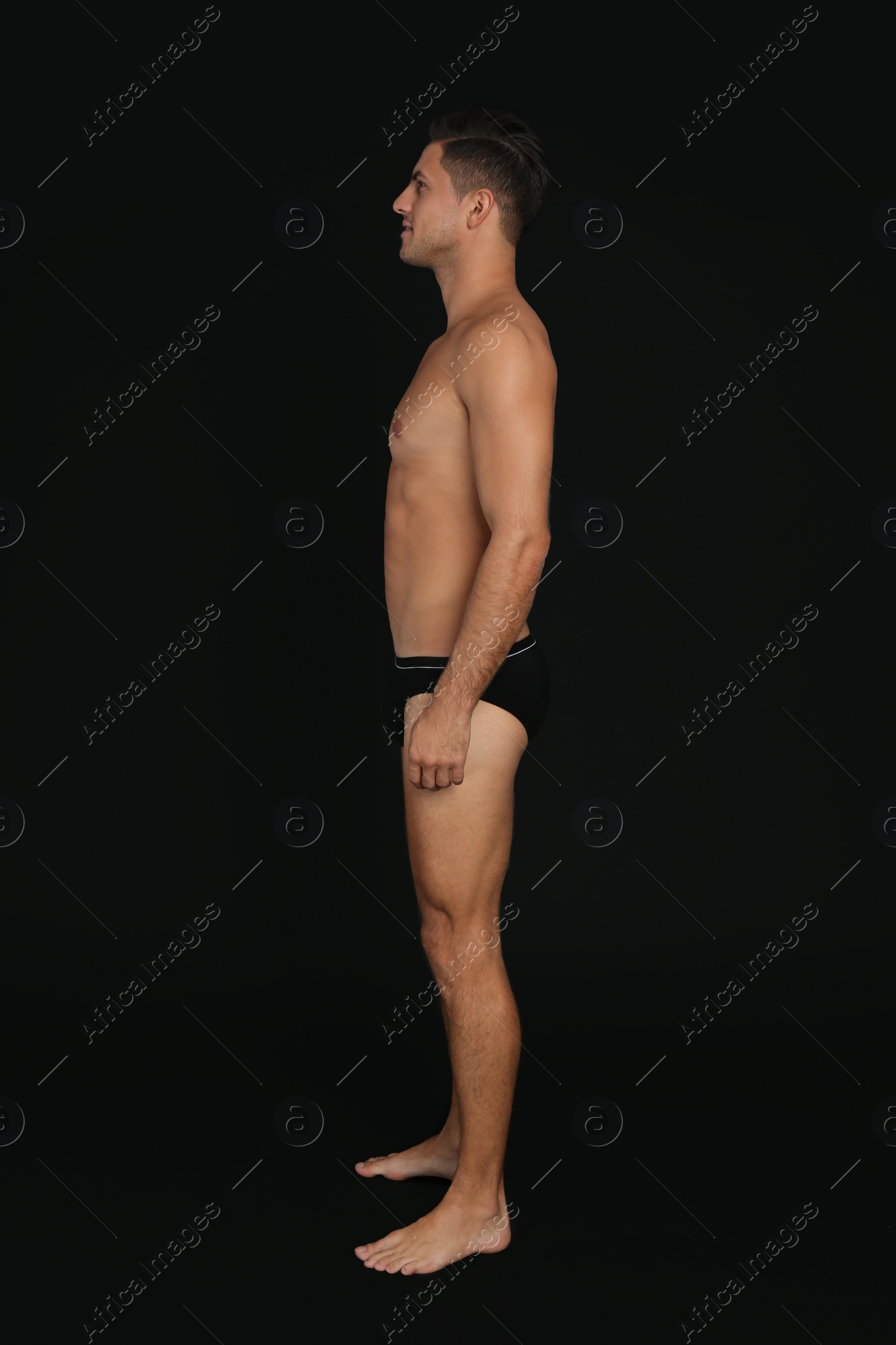 Photo of Handsome man in underwear on black background