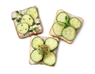 Photo of Tasty toasts with cucumber, cream cheese and microgreens isolated on white, top view