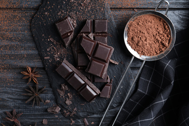 Photo of Flat lay composition with delicious dark chocolate on black wooden table