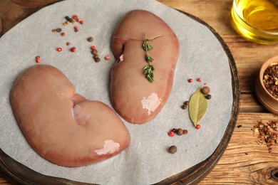 Photo of Fresh raw pork kidneys on wooden table