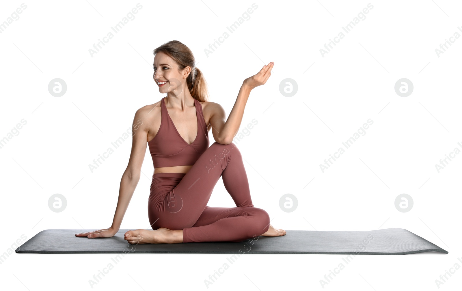 Photo of Young woman in sportswear practicing yoga on white background