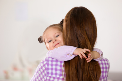 Photo of Young mother with little daughter at home