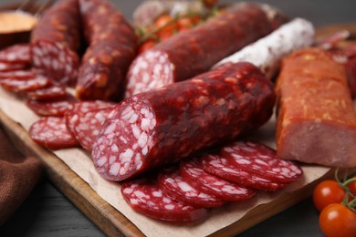 Different types of delicious sausages on black wooden table, closeup