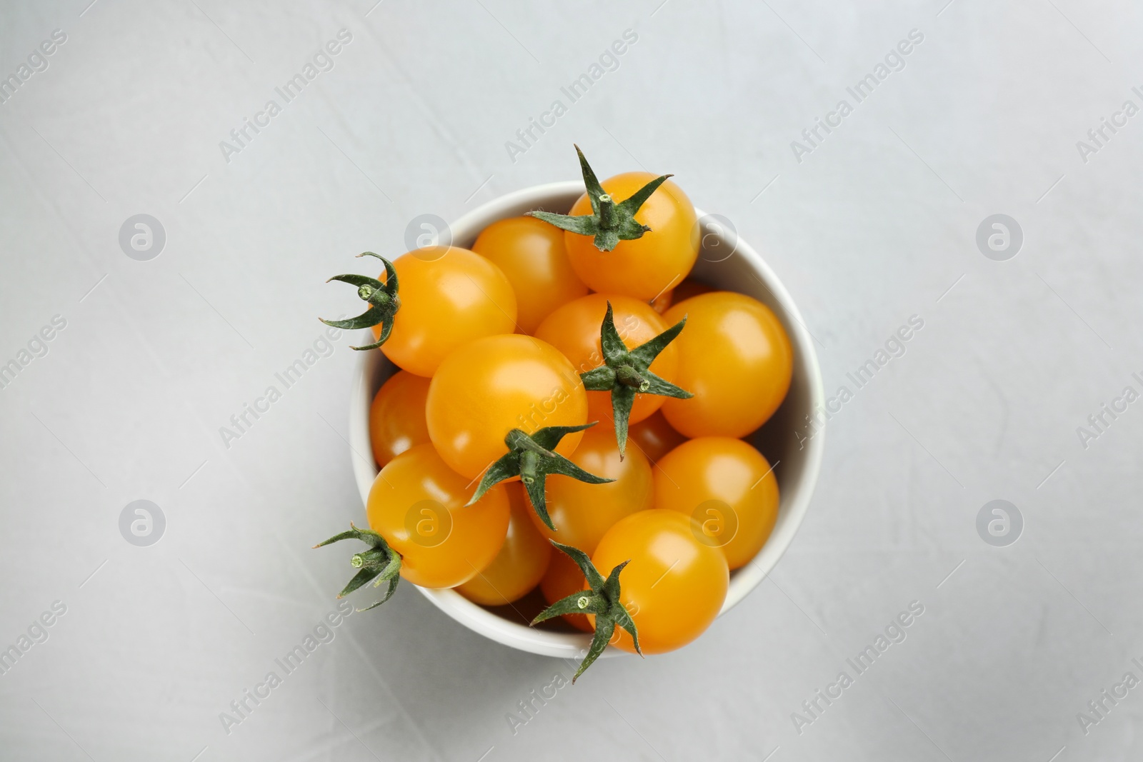 Photo of Ripe yellow tomatoes on grey table, top view