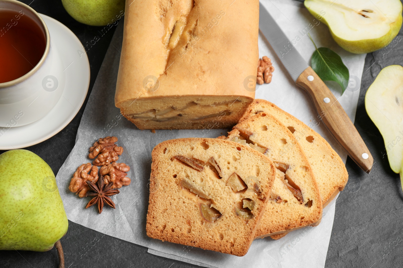 Photo of Flat lay composition with pear bread on black slate table. Homemade cake