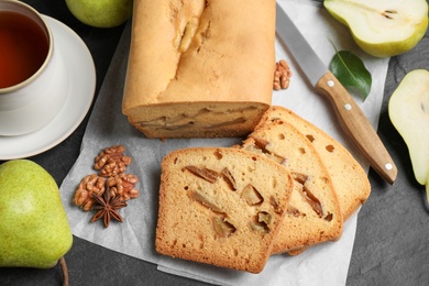 Photo of Flat lay composition with pear bread on black slate table. Homemade cake