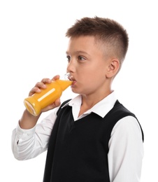 Little boy drinking juice on white background