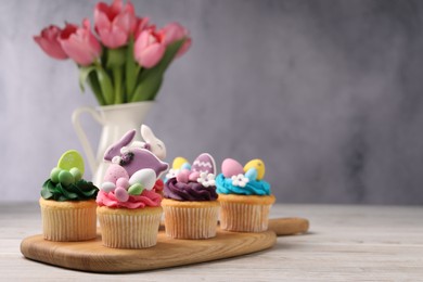 Photo of Tasty decorated Easter cupcakes on wooden table, space for text