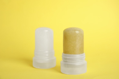 Photo of Natural crystal alum stick deodorants on yellow background