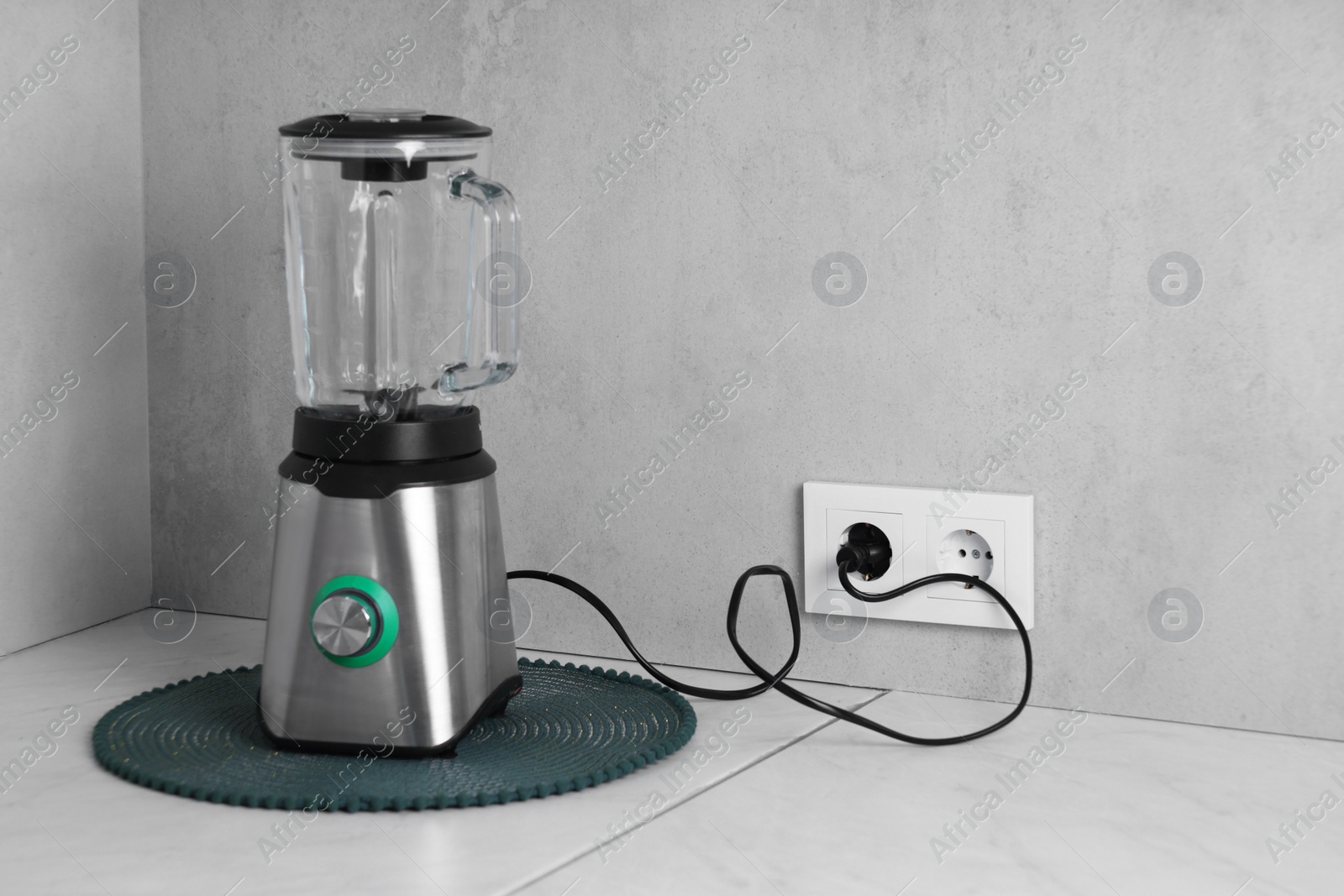 Photo of Electric blender plugged into power socket on white table