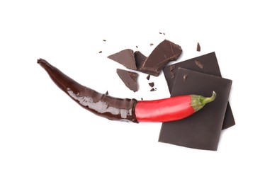 Photo of Red hot chili pepper and dark chocolate isolated on white, top view