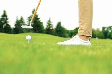 Photo of Man playing golf on green course. Sport and leisure