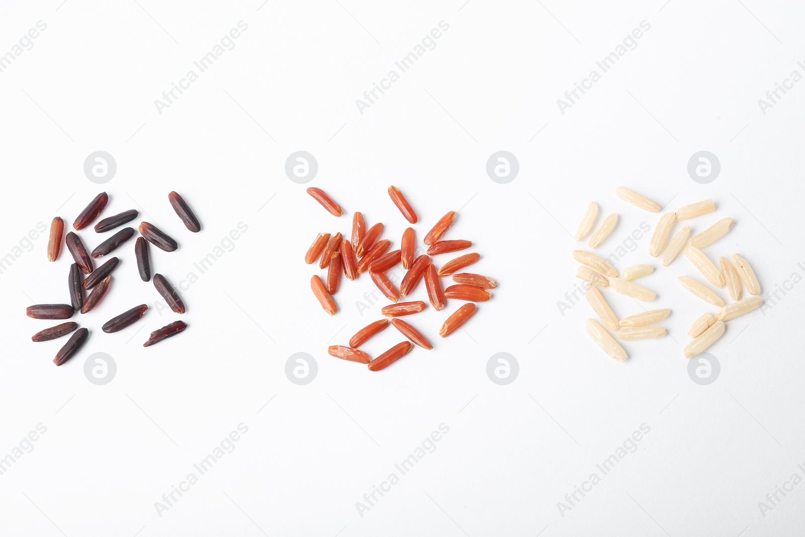 Photo of Different types of uncooked rice on white background, top view