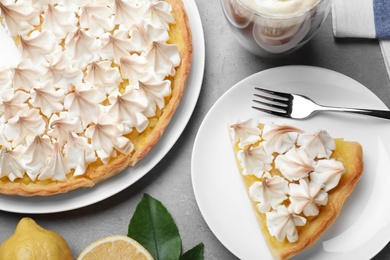 Cut delicious lemon meringue pie served on grey table, flat lay