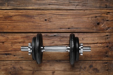 Photo of One barbell on wooden floor, top view. Space for text