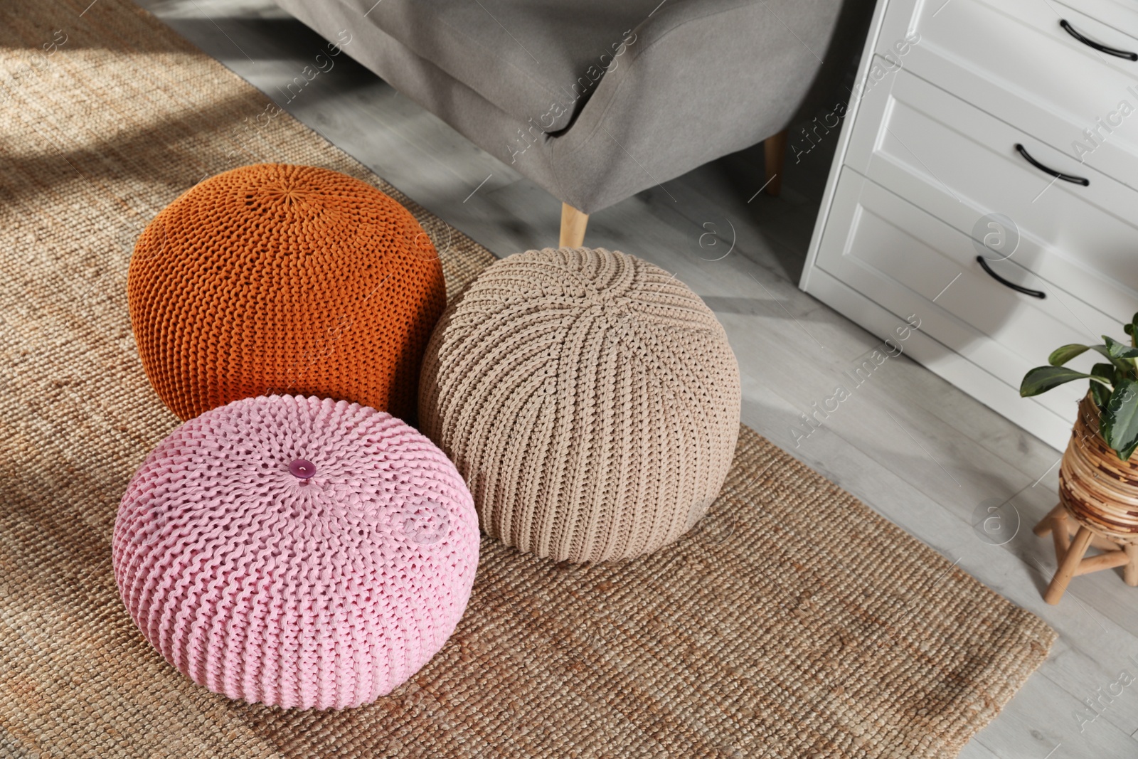 Photo of Stylish knitted poufs in room. Home design