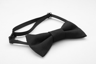 Photo of Stylish black bow tie on white background, closeup