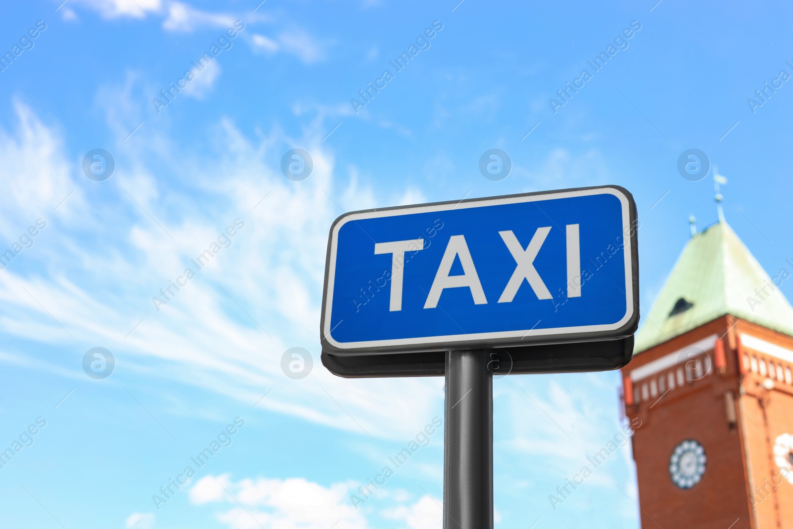 Photo of Post with TAXI sign against blue sky, low angle view