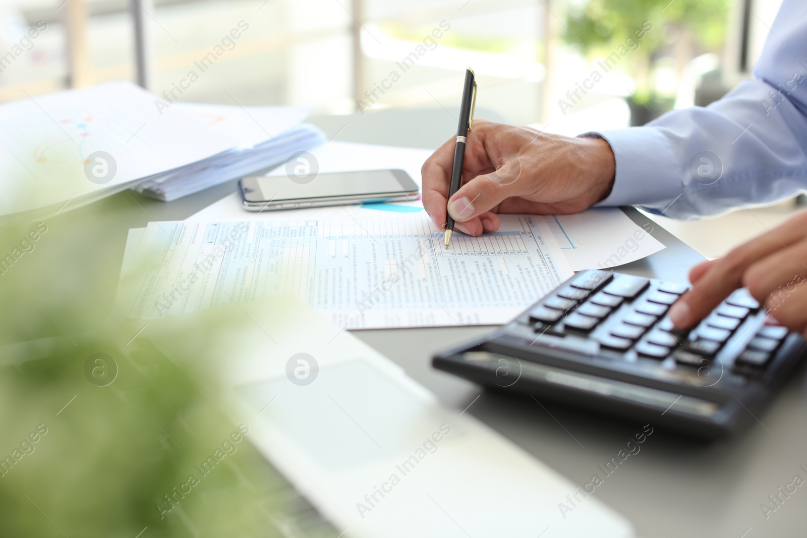 Photo of Tax accountant working with documents at table