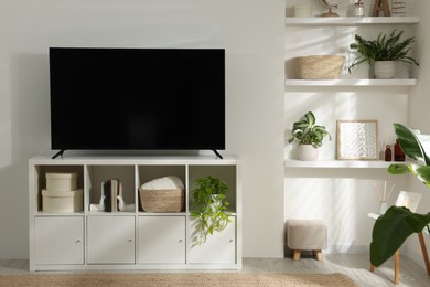 Photo of Stylish wide TV set on stand in room
