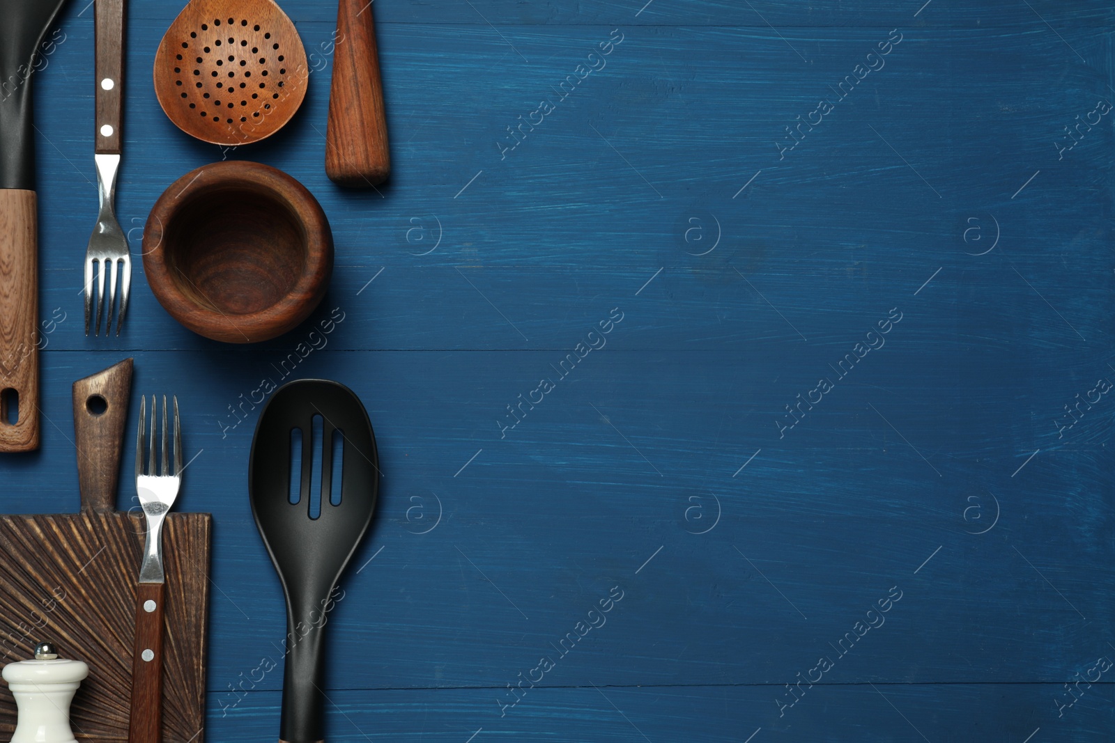 Photo of Set of different kitchen utensils on blue wooden table, flat lay. Space for text