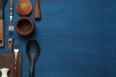 Set of different kitchen utensils on blue wooden table, flat lay. Space for text