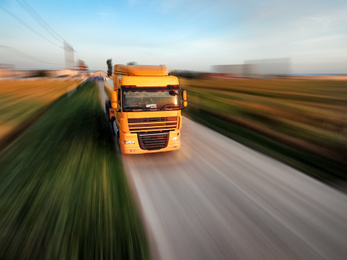 Image of Logistics concept. Truck on country road, motion blur effect 