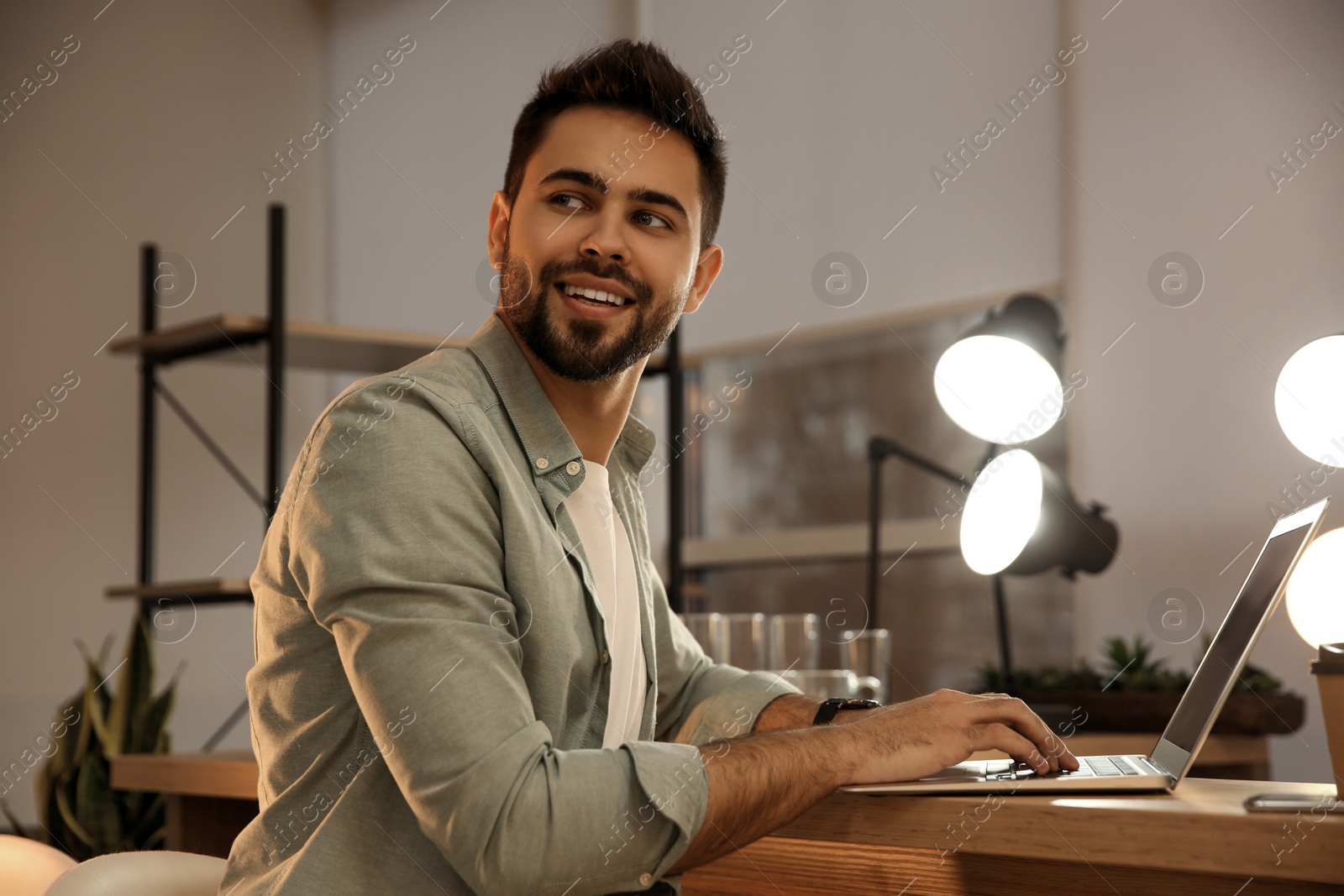 Photo of Man working with laptop at table in cafe