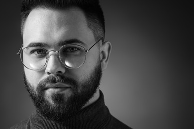 Photo of Portrait of handsome bearded man on dark background. Black and white effect