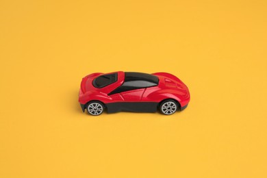 One red car on yellow background. Children`s toy