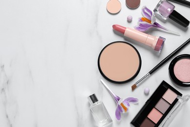 Photo of Flat lay composition with different makeup products and beautiful crocuses on white marble table, space for text
