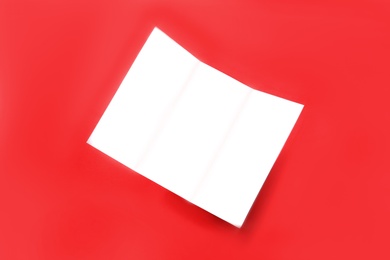 Photo of Empty flyer on red background. Mockup for design