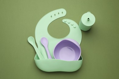 Baby feeding accessories and bib on background, flat lay